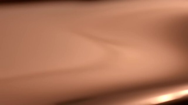 Abstract flowing copper metallic texture background with light reflections.