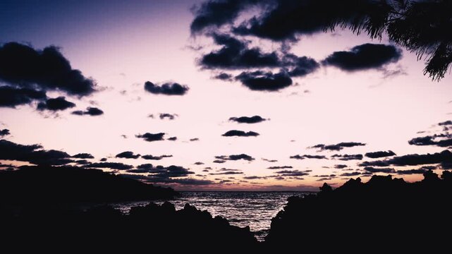 朝日に照らされる美しい波打ち際とシルエットの島影（スローモーション）
