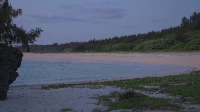 朝日に照らされる美しい波打ち際とシルエットの島影（スローモーション）