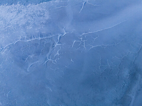 Aerial view of the salt crust patterns on the surface of Pink Lake, showing intricate white mineral formations against the blue-tinted landscape in Esperance, Western Australia, Australia.