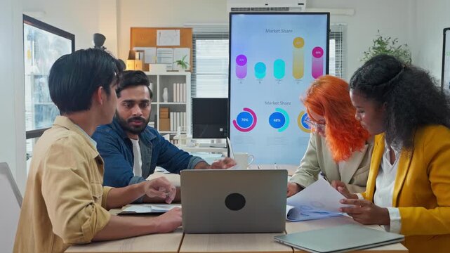 Diverse multiracial team presenting AI-powered marketing restructuring strategy on screen in modern open office, analysts reviewing business documents and data for corporate transformation concept