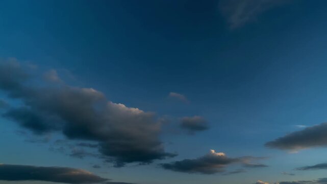 Golden hour clouds illuminated by sunset light against blue sky