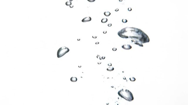 Water droplets are falling from above in a serene natural setting with clear liquid.
