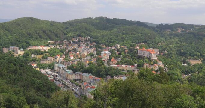 4K panning left motion of breathtaking view of the city buildings and surrounding mountains of the Karlovy Vary area, view from the observation deck of the Diana lookout tower, Karlovy Vary, Europe