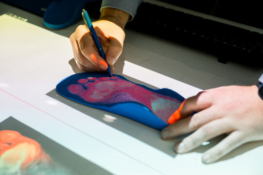 Podiatrist analyzing custom orthopedic insole for foot health