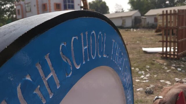 Authentic footage of an Indian stone sculpture artist hand-painting a Platinum Jubilee commemorative school logo sculpture in Odisha, India. The video showcases traditional craftsmanship
