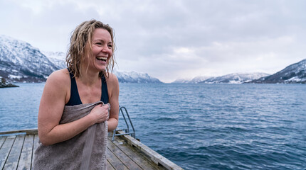 Fototapeta premium Woman laughing after cold water swim in fjord