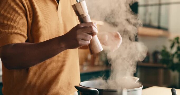 Salt, cooking and hands of man in kitchen at house for meal, dinner or supper with healthy diet. Steam, pot and male person with preparing dish for wellness, nutrition or recipe in apartment.