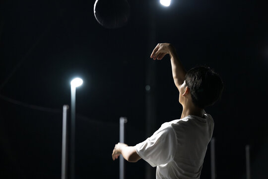 夜のコートでバスケットボールのジャンプシュートを練習や挑戦するスポーツと練習をイメージ　顔無し横顔