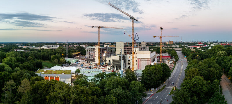 Aerial view of the construction site of a garbage incinerator at Volkspark with tall cranes and concrete structures near a road in Hamburg, Hamburg, Germany.