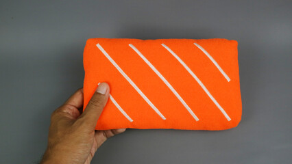 Hand Holding Small Salmon Slice Shaped Plush Pillow © Adipra