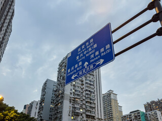 Blue road sign pointing to city streets beside apartment towers in Shanghai China © Rawf8