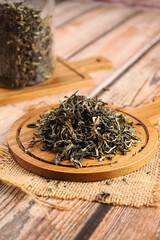 Dry tea leaves arranged on a wooden board in a kitchen