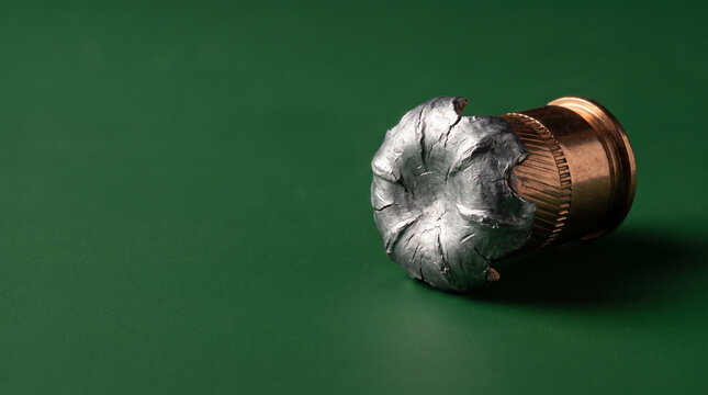Recovered fired bullet deformed nose macro forensic ballistic green.