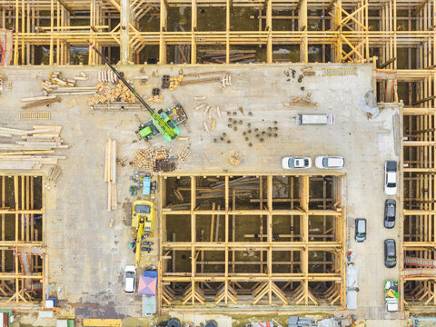 Aerial view of a construction site featuring a steel frame foundation, heavy machinery, and parked vehicles in Taiwan.