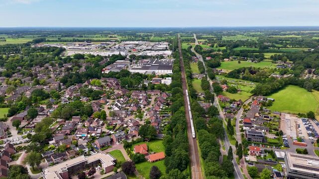 Aerial high angle shot of an intercity train traveling through a suburban town