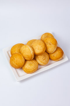 Traditional Kazakh baursaks fried dough bread on diagonal white plate isolated background