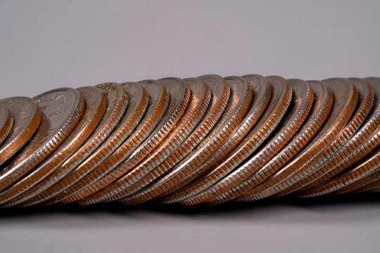 Coins stacked in a row on a flat surface showing details and texture