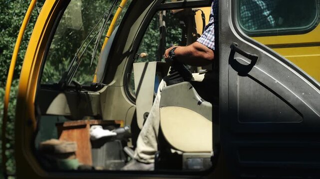 Professional crane operator controls a mobile crane from the cabin during industrial lifting operations. Heavy equipment, construction, logistics and material handling concept.
