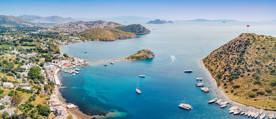 Obraz premium Gumusluk, Bodrum, enjoying a warm summer day, showing Rabbit Island and private yachts anchoring in the clear turquoise Aegean Sea