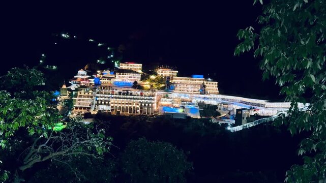 A stunning nighttime panorama of the Vaishno Devi Shrine brightly lit amidst the Himalayan landscape, attracting thousands of pilgrims throughout the year.