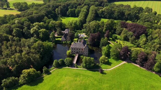 Medieval castle surrounded by a moat and lush forest in summer