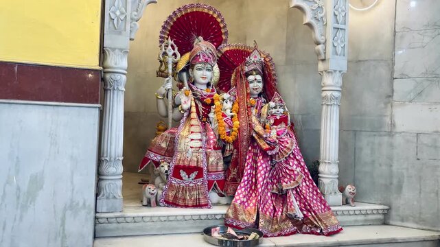 Sacred statue of Lord Shiva with his divine bull Nandi, adorned with vibrant flower garlands inside a Hindu temple. The devotional image reflects faith, strength, protection