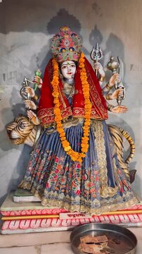 Sherawali Maa (Goddess Durga) adorned with vibrant traditional attire, sacred jewelry, and fresh flower garlands while seated on her divine lion inside a Hindu temple.