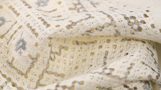 Cross stitch on linen fabric, handmade cross-stitch texture background, lace, natural eco folded linen tablecloth. Bio textile material backdrop, canvas top view, close up, rotating. 