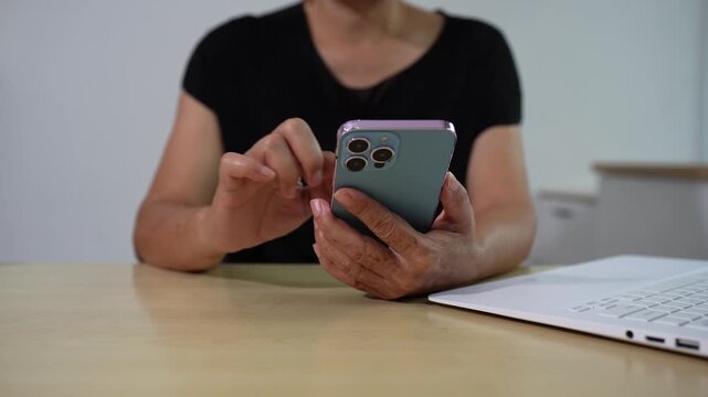 Female clicking internet search page on computer and smartphone touch screen at office.