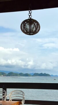 Vertical tropical beach resort view with hanging woven rattan lamp decoration footage. Perfect for travel vlogs, hospitality marketing, summer vacation promotions, and relaxing social media stories. 