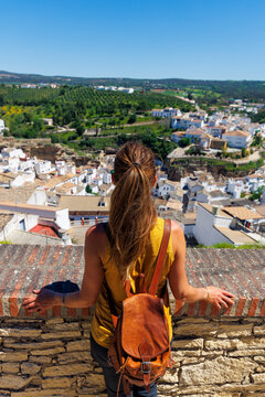 Female tourist with backpack looking at famous white village landscape in Spain, Setenil de las Bodegas