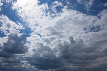 Obraz premium Large White Clouds Drifting Across a Bright Blue Sky. Expansive white clouds floating across a vivid blue sky, creating a peaceful natural background suitable for weather, travel, and summer themes.