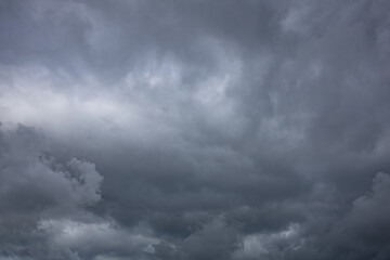 Obraz premium Heavy Rain Clouds Creating a Dark and Dramatic Sky. Dark dramatic storm clouds gathering in the sky before heavy rainfall. Atmospheric cloudscape featuring dense cumulonimbus formations
