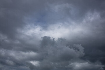 Fototapeta premium Dark Cloudscape with Approaching Storm and Rainfall. Dark dramatic storm clouds gathering in the sky before heavy rainfall. Atmospheric cloudscape featuring dense cumulonimbus formations