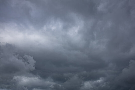 Heavy Rain Clouds Creating a Dark and Dramatic Sky. Dark dramatic storm clouds gathering in the sky before heavy rainfall. Atmospheric cloudscape featuring dense cumulonimbus formations