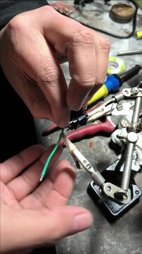 Close up of soldering wires to an audio jack connector with a soldering iron