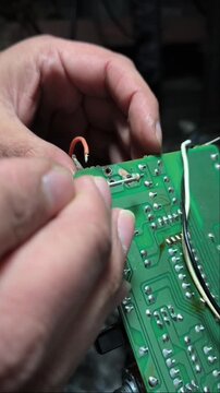 Detail shot of electronic engineering repair, checking points on a printed circuit board