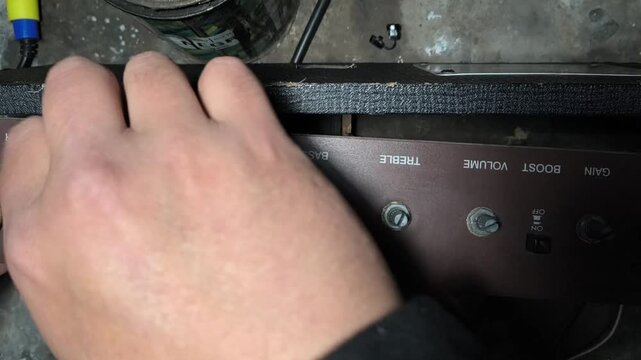 Technician disassembling a vintage guitar amplifier front panel for repair