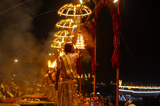Ganga aarti, Portrait of young priest performing holy river ganges evening aarti at assi ghat in traditional dress with hindu rituals.