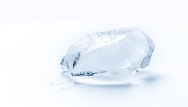Irregular clear ice chunk with droplets on clean white surface 氷の塊と水滴の白背景素材