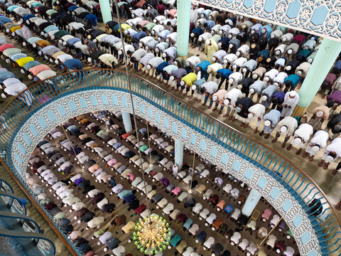 Dhaka, Bangladesh - 26 June 2026: Aerial view of Baitul Mukarram National Mosque with rows of men praying in unison, seen from an elevated balcony, featuring intricate architecture.