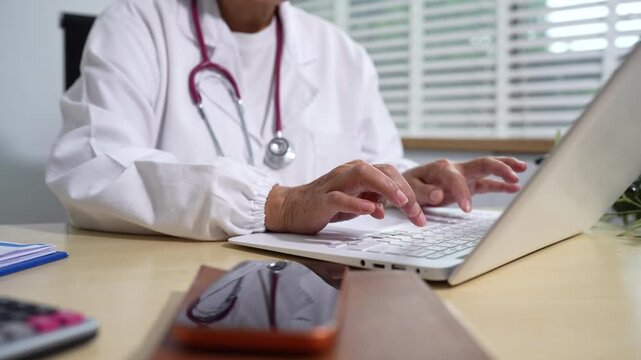 Doctor work on digital smartphone and computer healthcare doctor technology smartphone using computer in a modern office in the morning at the desk.