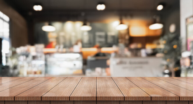 Empty wooden table top with lights bokeh on blur restaurant background.