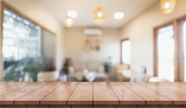 Empty wooden table top with lights bokeh on blur restaurant background.