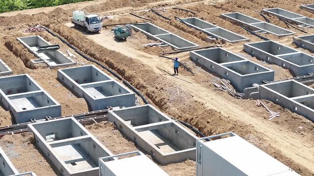 Construction site of concrete foundations for energy storage power station with workers and equipment
