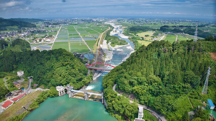 Fototapeta premium 梅雨の晴れ間の愛本橋と広がる黒部川扇状地とさらに奥に見える日本海