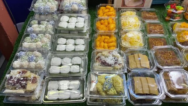 Traditional Thai Desserts at Vendor Stall, Colorful Display at Asian Street Food Open Market. Coconut Rice Desserts for Takeout in Bangkok, Thailand.