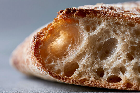 Freshly baked bread with golden crust and airy crumb. Soft interior shows large, inviting bubbles. Warm, comforting texture invites sensory delight. Hue city, Vietnam - 02 June 2026