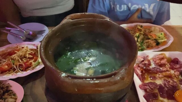 Jim Jum Thai Clay Charcoal Hotpot Isaan Style Traditional Soup with Raw Pork Beef Meat & Herbs Vegetables. Asian Street Food Restaurant in Bangkok Thailand.
